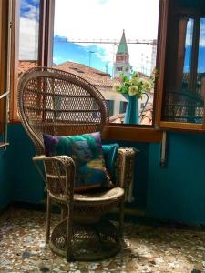 Una silla de mimbre con una almohada colocada en una ventana. en Saint Mark's view, en Venecia