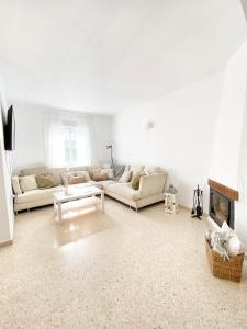 a living room with two couches and a fireplace at Townhouse w/sea view & garden in Estepona