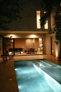a swimming pool in front of a house at night at TOHO VILLA 4BED WITH POOL & JACUZZI in Tulum