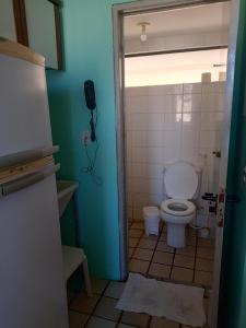 a bathroom with a toilet and a phone on the wall at Dúplex mar de Pajuçara in Maceió