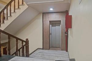 einen Flur mit Treppe und Tür in einem Gebäude in der Unterkunft OYO Kiran Palace in Jaipur