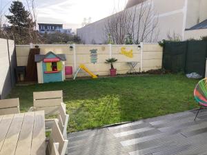 a backyard with a play yard with a fence at La Maison des Massena in Noisy-le-Grand