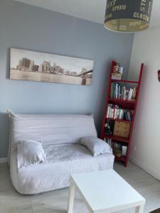 a room with a white bed and a book shelf at La Maison des Massena in Noisy-le-Grand
