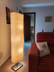 a floor lamp in a living room with a couch at Come a casa in LʼAquila