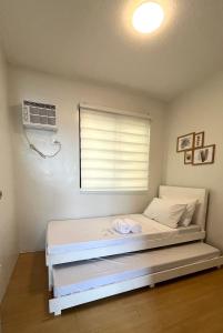 Schlafzimmer mit einem Bett, einem Fenster und einem Ventilator in der Unterkunft Scandinavian design 2BR @ Ortigas, Pasig in Manila