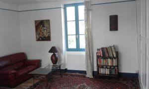 uma sala de estar com um sofá vermelho e uma janela em le jardin du controleur em Valence-dʼAgen