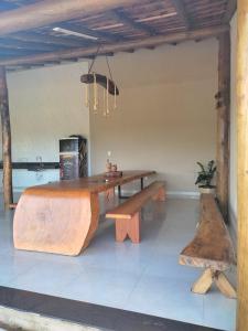 una mesa de madera y un banco en una habitación en Rancho Moreira en Piumhi