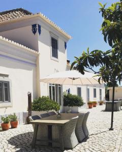 uma mesa e cadeiras em frente a uma casa branca em Casal da Eira em São Brás de Alportel