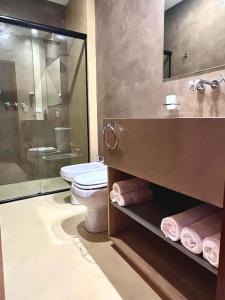 a bathroom with a toilet and a glass shower at Hotel Cerros del Norte in Tilcara