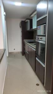 eine Küche mit Herd und Mikrowelle in der Unterkunft APARTAMENTO VACACIONAL - ISLA DE MARGARITA - Th in Porlamar