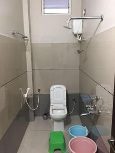 a bathroom with a toilet and a green stool at Ajay Residency and Convention Hall / Lodge Near Me / Lodge Rayachoti in Rāyachoti