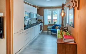 a kitchen with white cabinets and a blue chair at Lovely Apartment In Rjukan in Rjukan