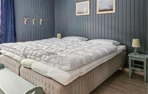 Cozy Apartment In Rjukan With House A Panoramic View في ريوكان: سرير أبيض كبير في غرفة نوم مع جدار