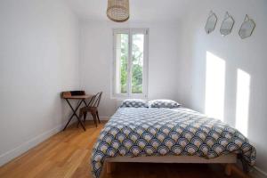 Schlafzimmer mit einem Bett, einem Fenster und einem Tisch in der Unterkunft Maison de ville haut de gamme En face du stade de France in Saint-Denis