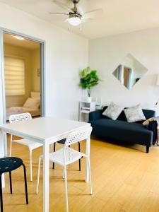 ein weißer Esstisch und Stühle im Wohnzimmer in der Unterkunft Scandinavian design 2BR @ Ortigas, Pasig in Manila