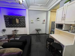 a living room with a couch and some stools at The Yafé Bastos 13 in Yaoundé
