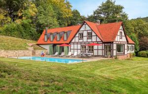 a house with an orange roof and a swimming pool at Amazing Home In Eiterfeld With Wifi in Eiterfeld