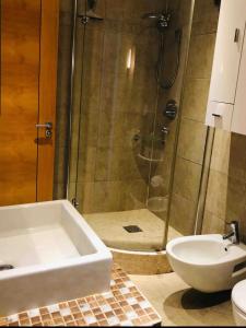 a bathroom with a shower and a tub and a sink at APARTMENT IN OCEAN VILLAGE, SLEEPS UP TO 6 in Gibraltar
