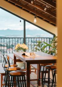 een eetkamer met een tafel en stoelen op een balkon bij Miền Sương Khói Homestay Đà Lạt in Da Lat