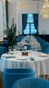 a long dining room with white tables and blue chairs at Luxury PANORAMA sea view apartment & Central Batumi in Batumi