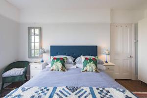een slaapkamer met een groot bed met een blauw hoofdeinde bij Bayside House in Westgate-on-Sea
