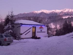 a small building with lights on it in the snow at The Sun Chalet by Touch the Sky in Moieciu de Jos