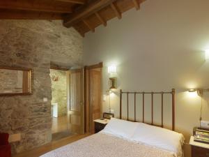 a bedroom with a bed and a stone wall at Casa Perfeuto Maria in Cabana Moura  +56 photos