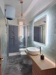 a bathroom with a sink and a toilet and a mirror at La casa sull'albero in Palermo