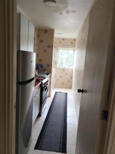 a kitchen with a white refrigerator and a stove at DEPARTAMENTO COSTANERA PELLUCO, PUERTO MONTT in Puerto Montt