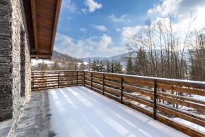 a balcony of a house with snow on it at Chalety Bystra in Horná Lehota