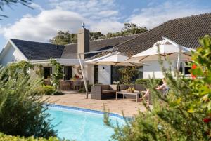 a house with a swimming pool in front of a house at The Dongola Guesthouse in Cape Town