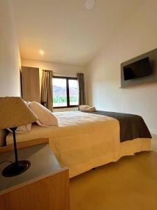 a bedroom with a large bed with a window at Hotel Cerros del Norte in Tilcara