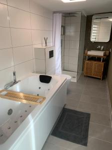 a large white bath tub in a bathroom at Ferienstüble im Zabergäu- Ferienwohnung in Brackenheim