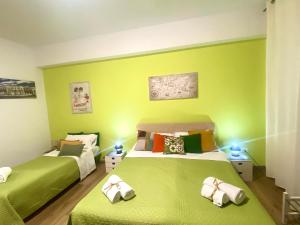 two beds in a room with green walls at LeAlbe di Sicilia in Palermo
