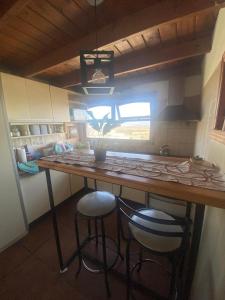 una cocina con barra y 2 taburetes en un bar en Ohana en Ushuaia