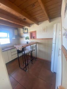 een keuken met een tafel met stoelen en een koelkast bij Ohana in Ushuaia