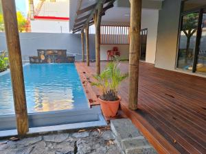 a house with a swimming pool on a wooden deck at Three bedrooms House on first floor and access to swimming pool in Roches Brunes