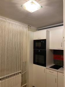 kuchnia z białymi szafkami i oknem w obiekcie Cat Garden Family Apartments Riga w Rydze