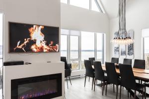 jadalnia z kominkiem i stołem z krzesłami w obiekcie Amazing Condo with Spectacular Views for 8ppl w mieście Baie-Saint-Paul