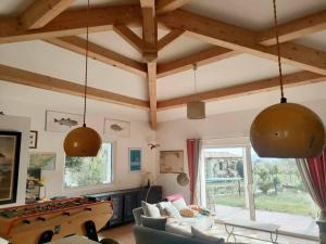 a living room with two pendant lights and a pool table at Emplacement idéal dans le Var ! in Cuers