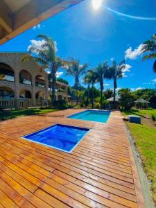 a wooden deck with a pool and a house at Lagoon Breeze Guest House in Knysna