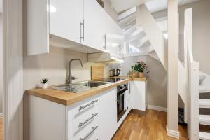 a kitchen with white cabinets and a staircase at New! Modern City Apt: Central w/ Private Entrence in Bergen