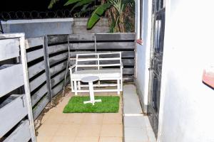 una silla sentada en un parche de hierba en un balcón en Minari Holiday Homes, en Bungoma