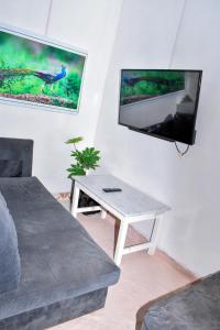 sala de estar con mesa y TV en Minari Holiday Homes, en Bungoma