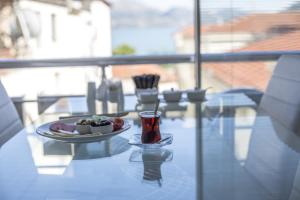 a glass table with a plate of food and a drink at Golden Apple Hotel in Egirdir