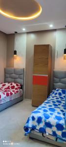 sypialnia z 2 łóżkami i komodą w obiekcie Jenan elkhyer Ben guerir w mieście Benguerir
