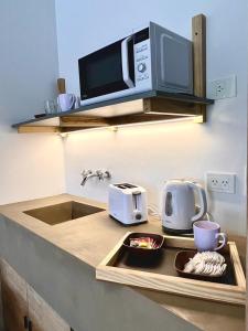 a kitchen with a sink and a microwave at Hotel Cerros del Norte in Tilcara