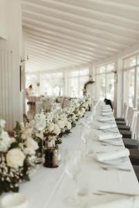 długi biały stół z białymi kwiatami w obiekcie Garni hotel Oblačinsko jezero w mieście Oblačina