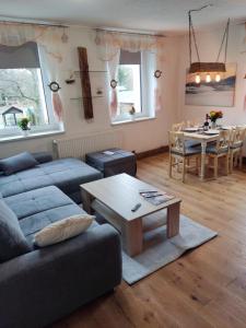 a living room with a couch and a table at Ferienwohnung 3 am Hofladen Hellendorf in Bad Gottleuba +25 photos