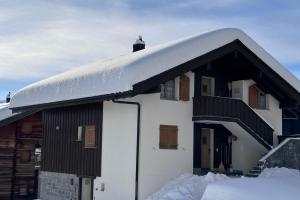 pokryty śniegiem dach domu ze śniegiem w obiekcie Serenella Apartment w mieście Riederalp